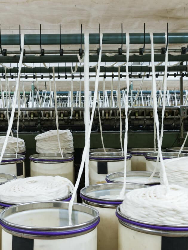 threads pulling out of barrels to be woven.